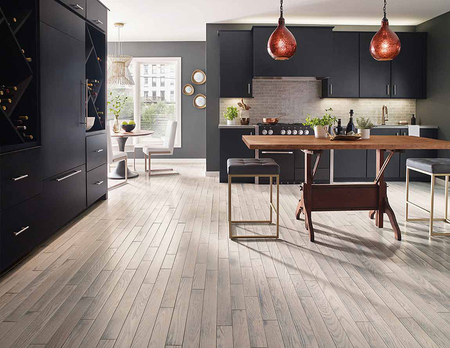 Modern kitchen design with ebony stained cabinets, pendulum lights, and lightly stained wood floors. 